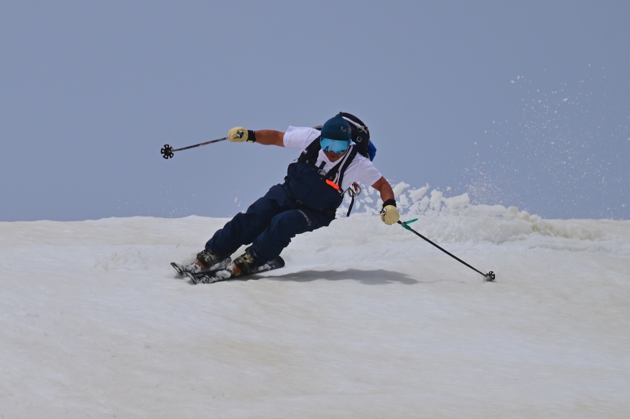 Taku making a ski turn with a spray of snow